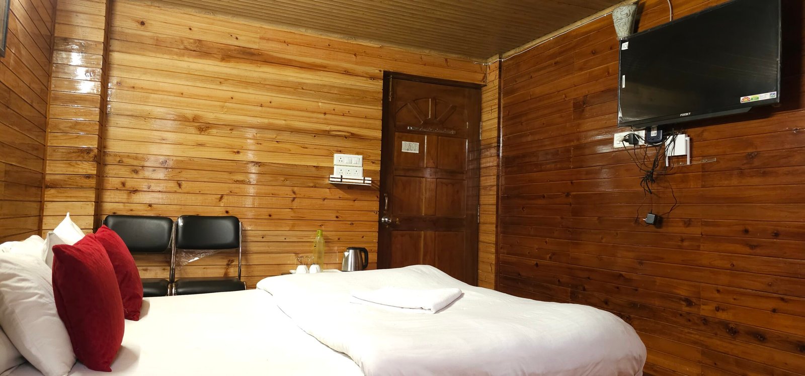 Hotel room near Mall Road Darjeeling featuring luxury wooden decor and comfortable bedding