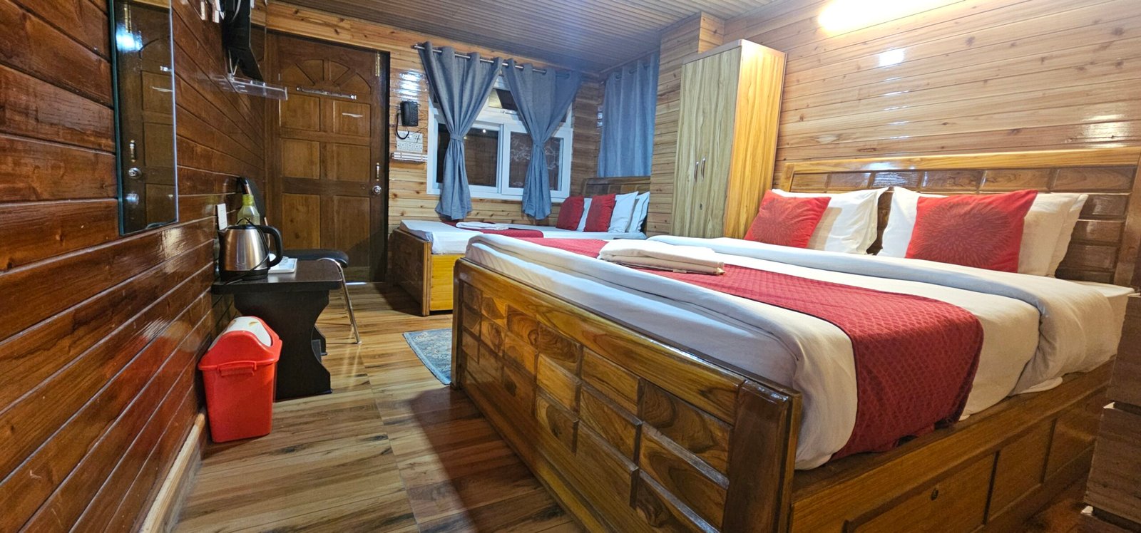 Quad family room near Mall Road Darjeeling with wooden interiors and four bed accommodation